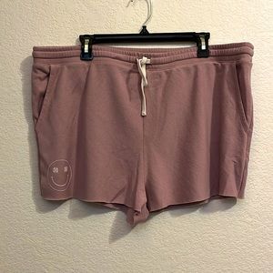 Light mauve shorts with small 4 leaf clover smiley face